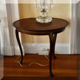 F07. Small mahogany round side table with brass overlay. 24”h x 21”w - $148 